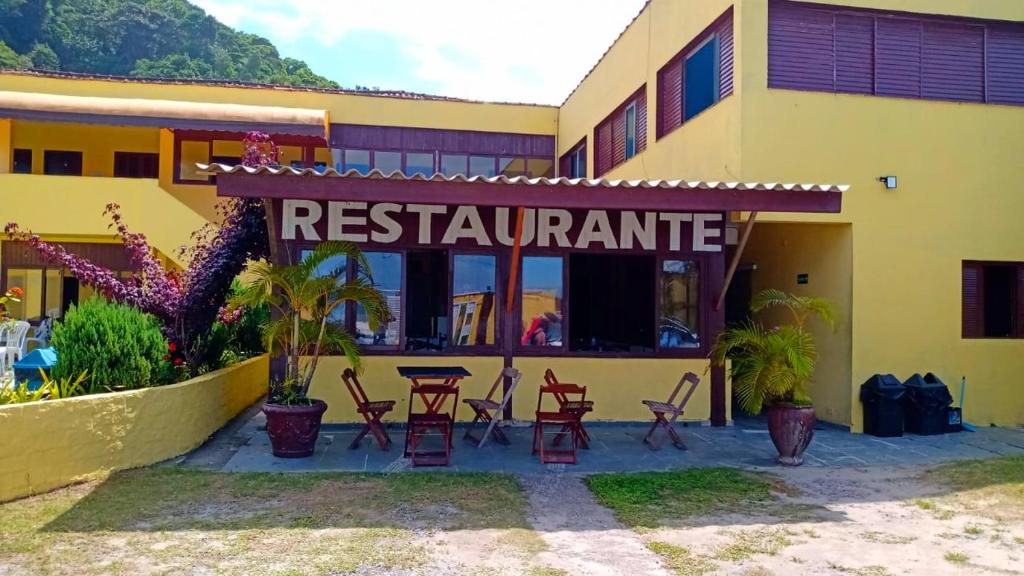 een restaurant met tafels en stoelen voor een gebouw bij Guarujá H Pousada in Guarujá