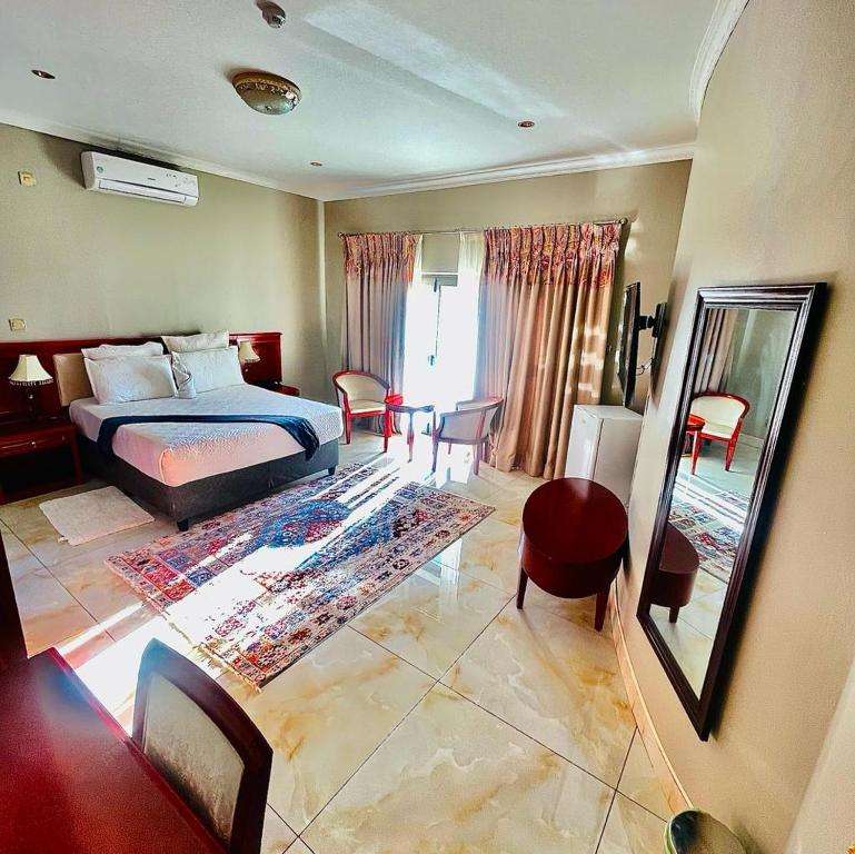 ein Schlafzimmer mit einem Bett und einem Spiegel in einem Zimmer in der Unterkunft Rosenia Boutique Hotel 20792 Block 3 in Gaborone