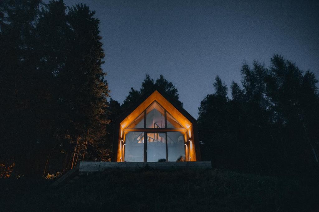 ein kleines Haus mit einem beleuchteten Fenster in der Nacht in der Unterkunft Private cabin in the middle of nature 