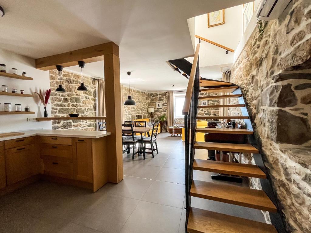 a kitchen and dining room with a stone wall at Old stone house Klarić in Brela