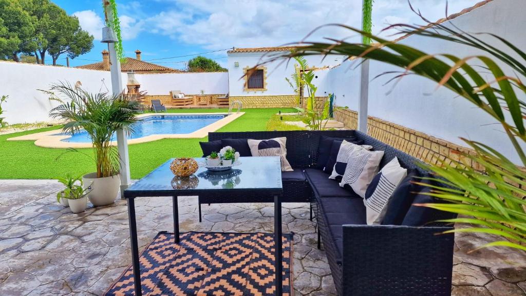 a patio with a blue couch and a table at Villas Luins in Chiclana de la Frontera