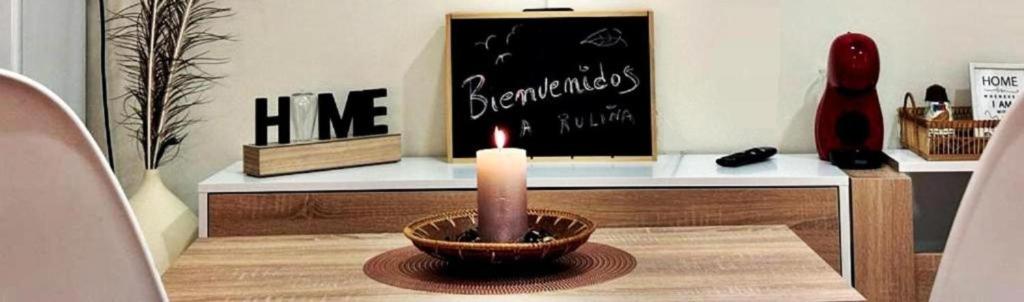 una vela en un tazón sobre una mesa con una pizarra en Holibai, Ruliña ,Centrica Private Ensuite, Baiona, en Baiona