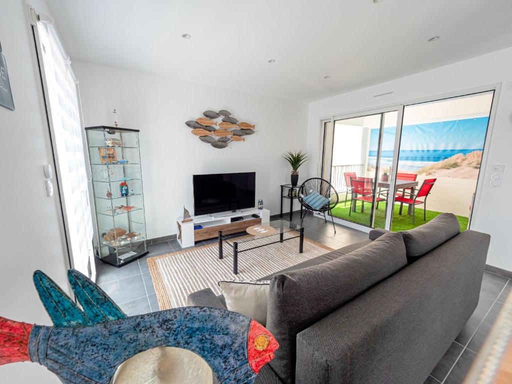 un salon avec un canapé et une télévision dans l'établissement Magnifique loft au coeur de Saint Gilles 5 pers, à Saint-Gilles-Croix-de-Vie