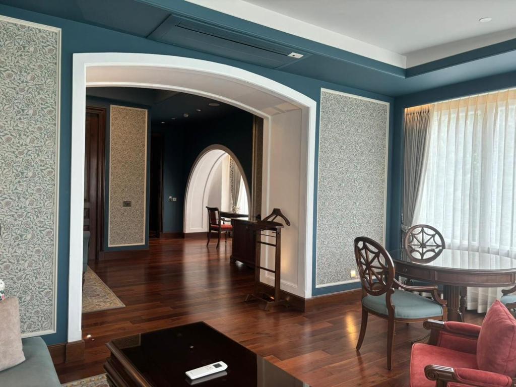 uma sala de estar com paredes azuis e uma mesa e cadeiras em Welcomhotel by ITC Hotels, The Savoy, Mussoorie em Mussoorie
