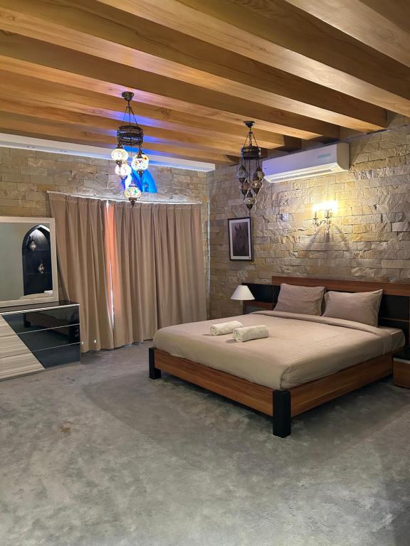 um quarto com uma cama grande e uma parede de pedra em Valley Guest Home em Nizwa