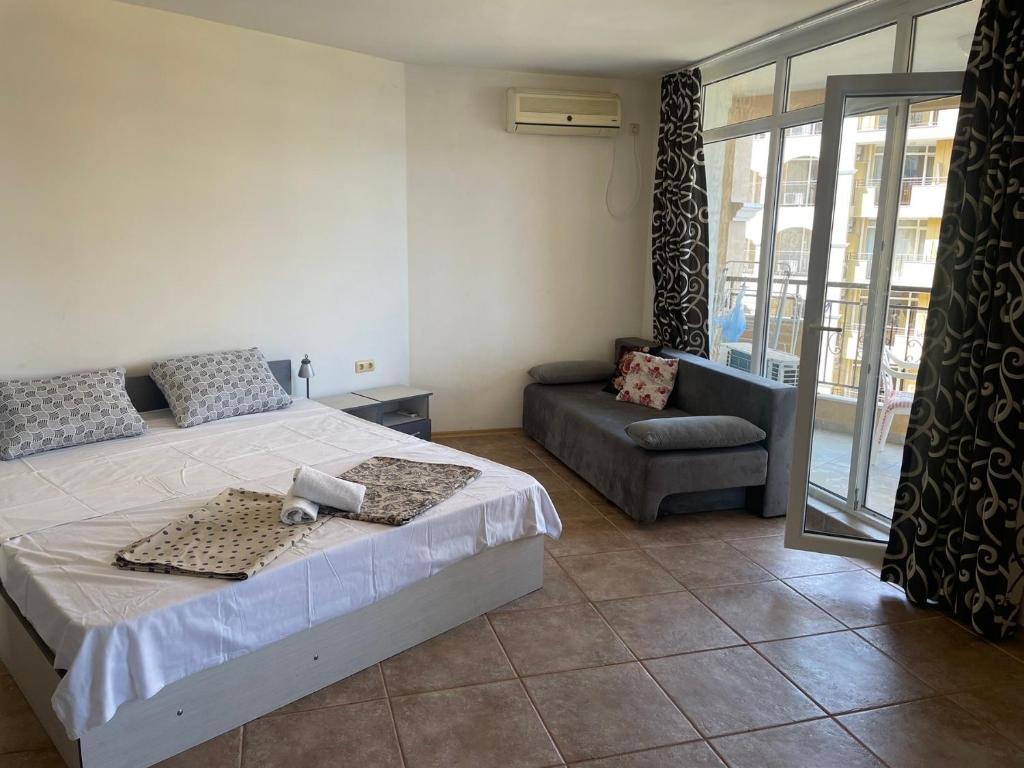 ein Schlafzimmer mit einem Bett und einem Sofa in der Unterkunft Midia SP Apartments in Aheloy