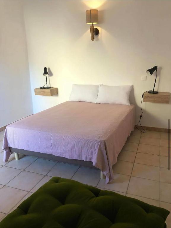 a bedroom with a bed with two lamps on the wall at La maison de vacances in Lauris