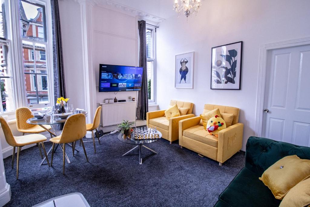 a living room with a couch and chairs and a table at Oxford Street Grandeur - Perfect for Large Groups in London