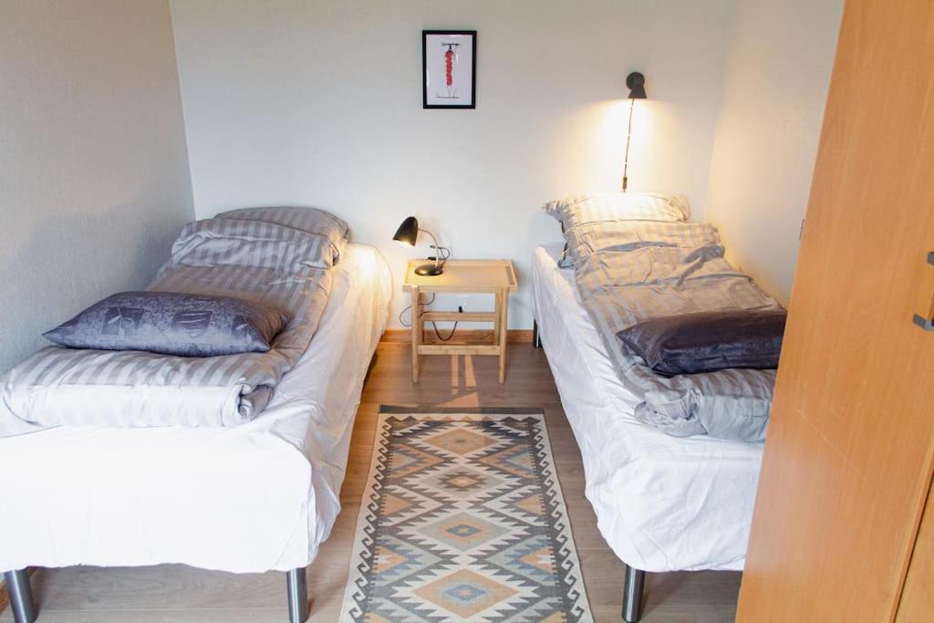 Cette chambre comprend deux lits et une table avec une lampe. dans l'établissement 1 BR apartment for 4 guests in Tórshavn, à Tórshavn