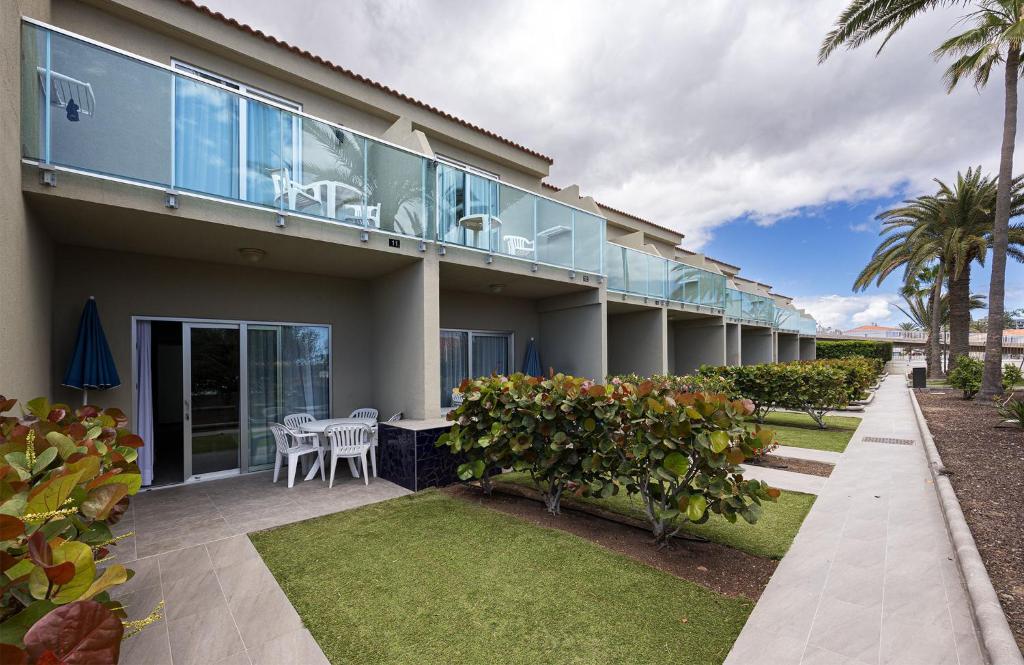 a house with a balcony with a table and chairs at Smartr Maspalomas Corinto in Playa del Ingles