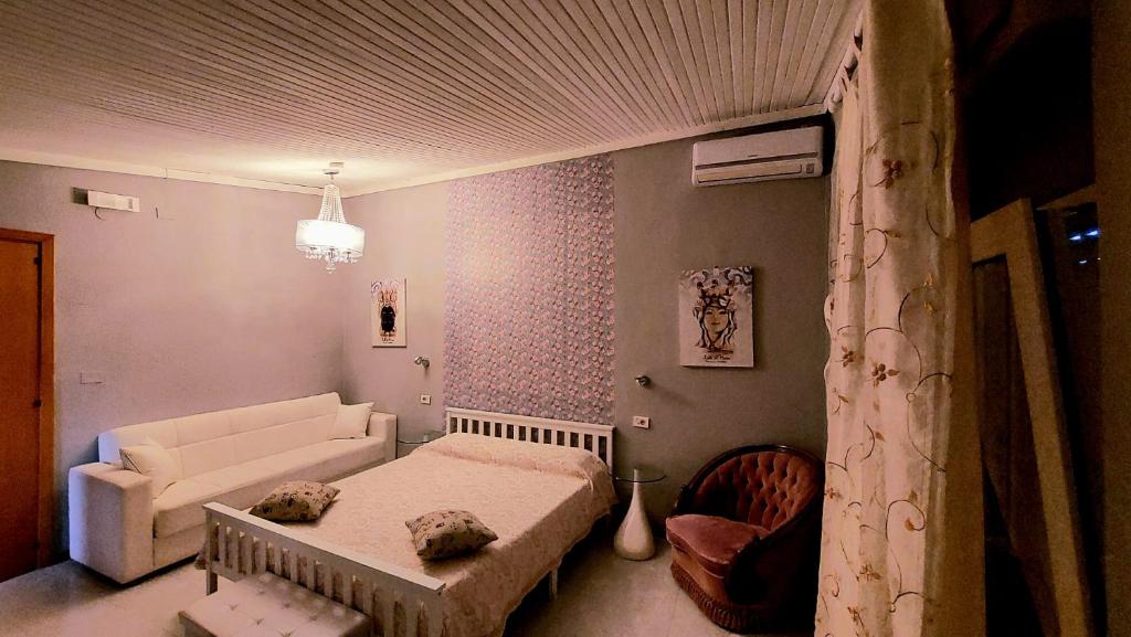 a living room with a bed and a couch at Il Mirto E La Rosa in Arenella