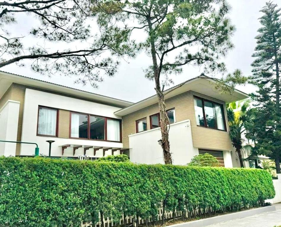 une maison avec une haie devant elle dans l'établissement Mattina Villa, à Hạ Long