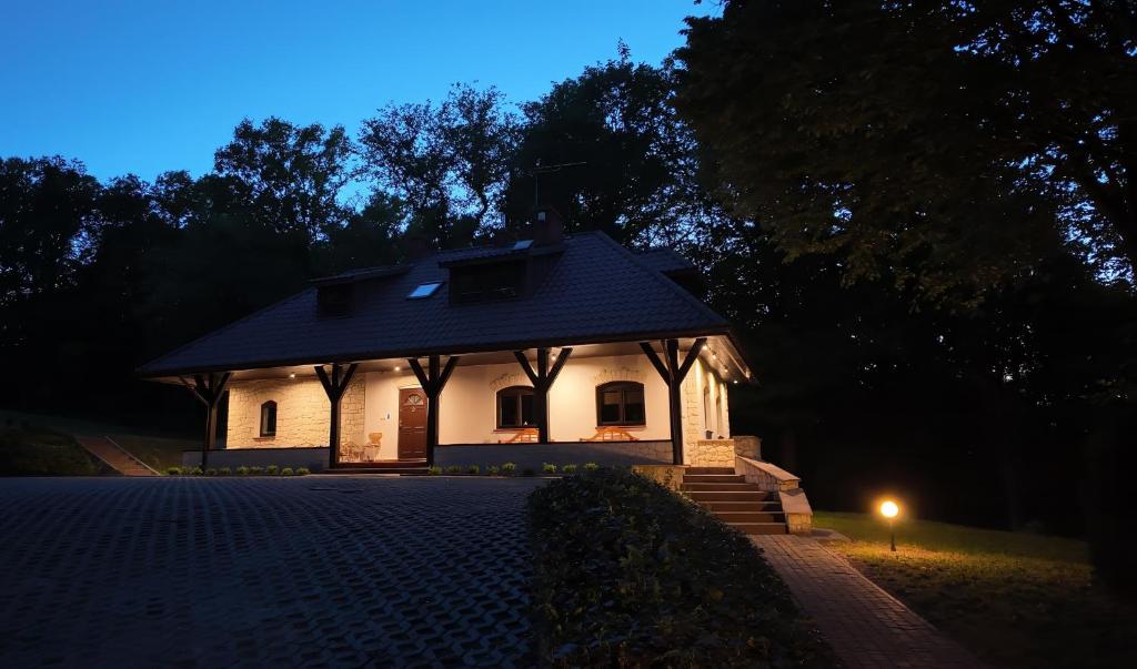 ein kleines weißes Haus in der Nacht mit Licht in der Unterkunft Leśne Echo in Kazimierz Dolny