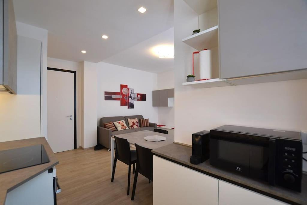 a kitchen and living room with a table and a microwave at Casa Jordan - Your Home Everywhere - Pordenone in Pordenone