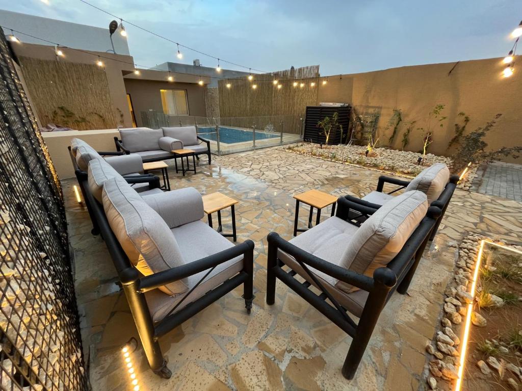 um pátio com espreguiçadeiras e uma piscina em شاليهات حائط حجري em Riyadh