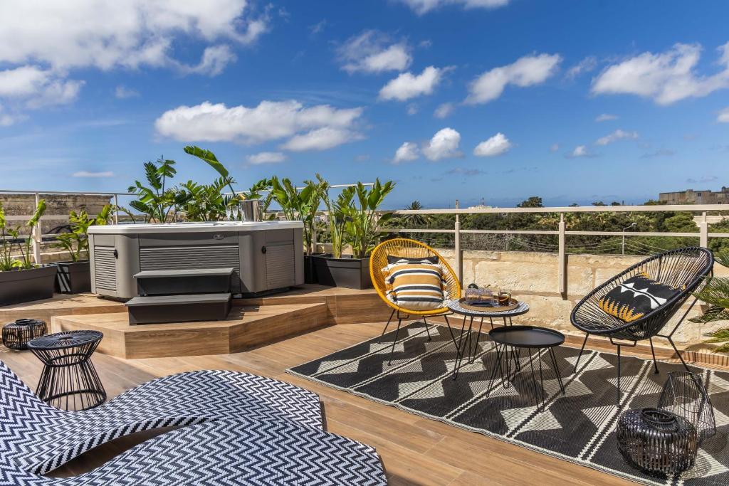 a patio with chairs and a television on a deck at Maison Medina in Mdina