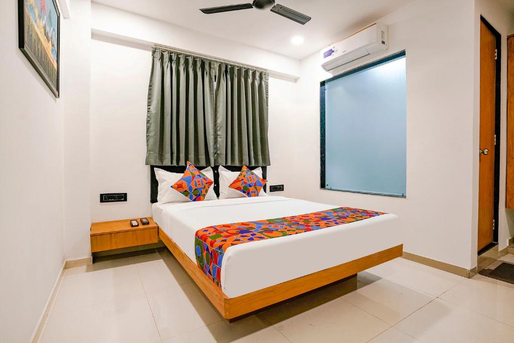 a bedroom with a large bed with a window at FabHotel Royal King I in Surat