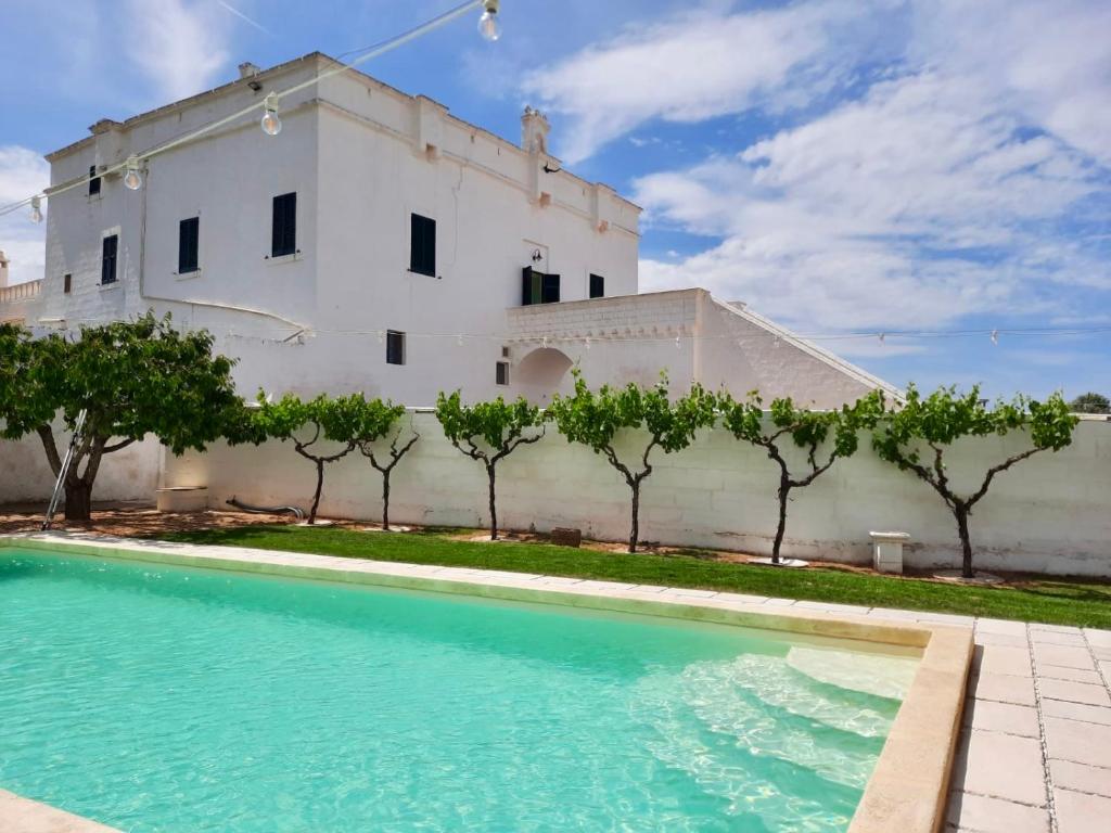 a building with a swimming pool in front of a building at Masseria Mammella in Monopoli