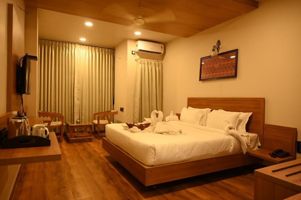 1 dormitorio con 1 cama blanca grande en una habitación en Varaha Residency Lodging and Banquet, en Hubli