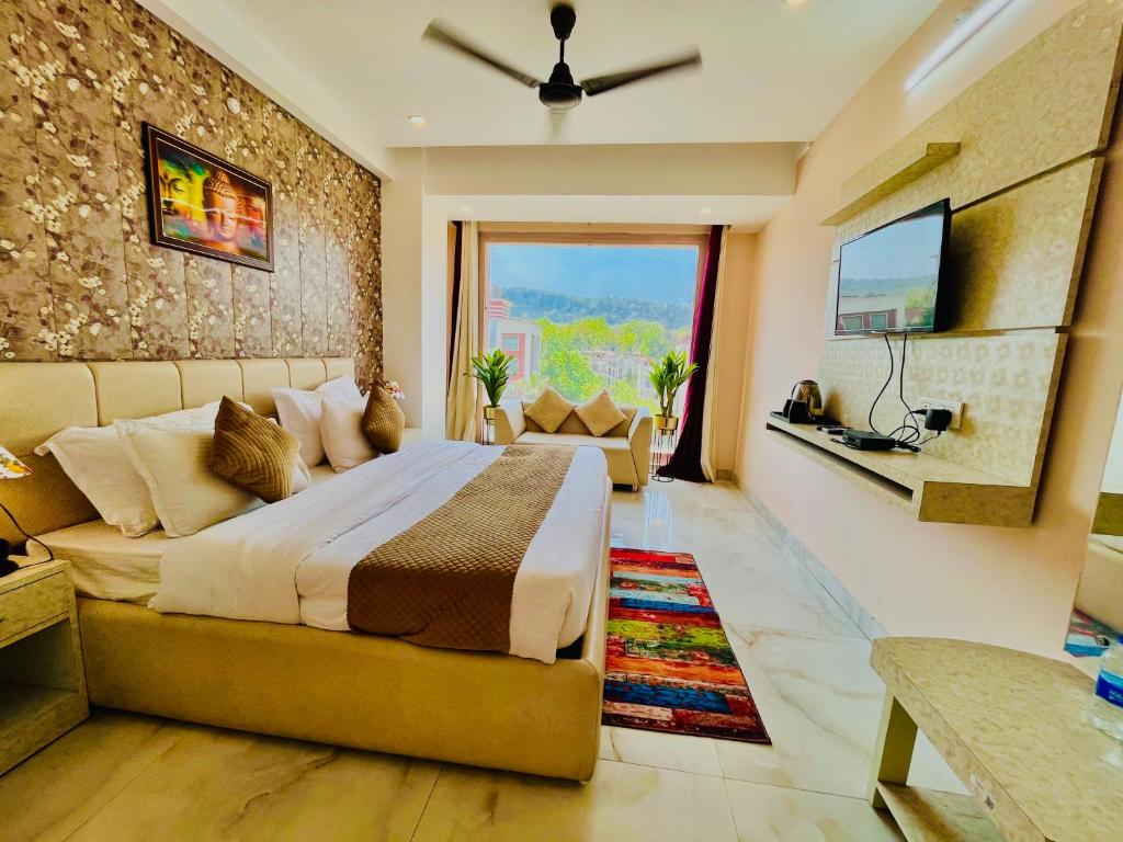 een slaapkamer met een groot bed en een televisie bij Spring Sky - A Four Star Luxury Hotel in Rishīkesh