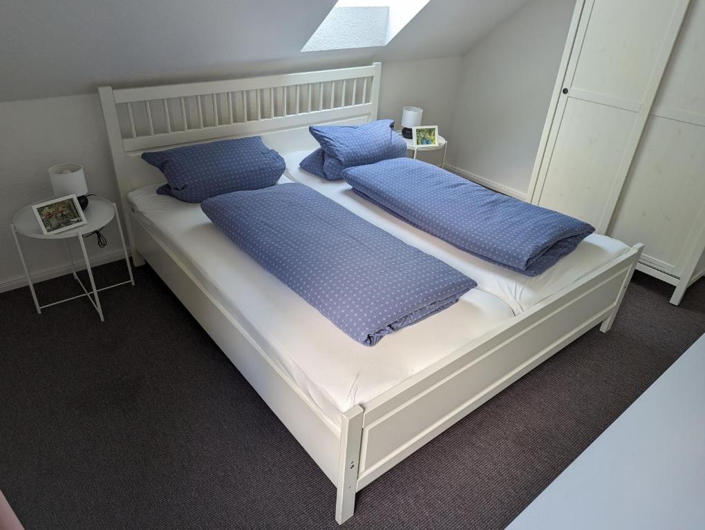 1 dormitorio con 2 camas y almohadas azules en Ferienwohnung Möhle - Westerstede, en Westerstede