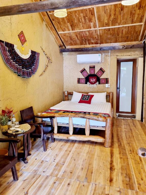 a bedroom with a bed and a table and chairs at Mam Da Homstay in Na Hang