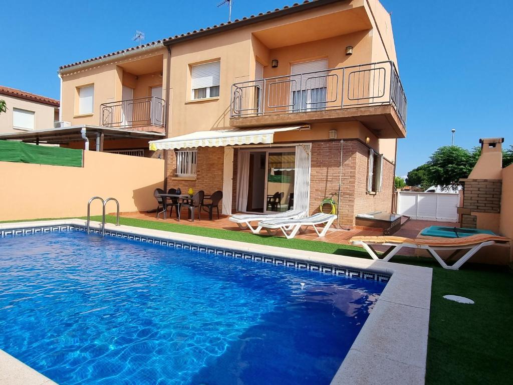uma casa com piscina em frente a uma casa em L' Escala Casa Mallols Xrm04 em L'Escala