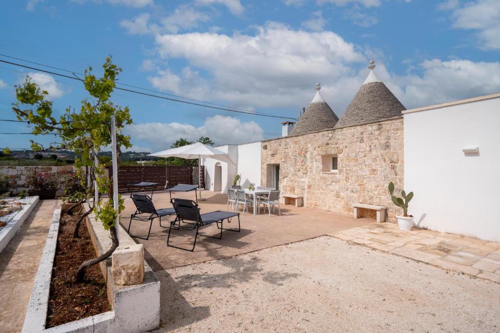a patio with chairs and tables and a building at Trulli Miriam: Enchanting Apulian Getaway in Martina Franca