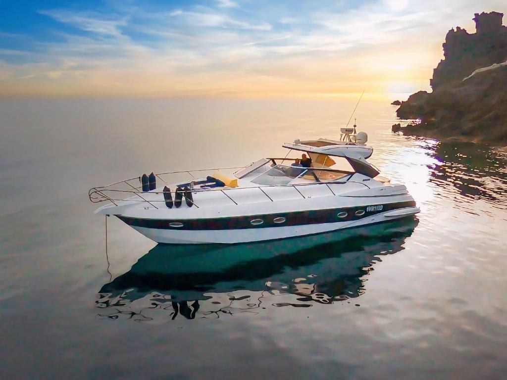 Una barca bianca in acqua vicino a una scogliera di Yacht Mea - Pantelleria a Pantelleria