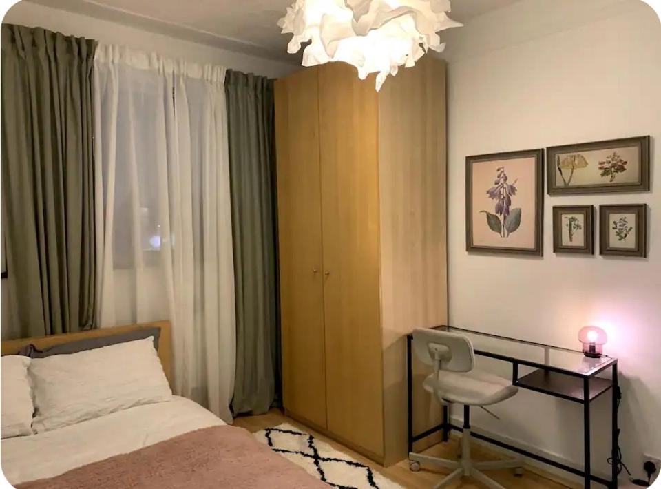 una camera da letto con scrivania, letto e lampadario a braccio di Kenwood Gem a Edmonton