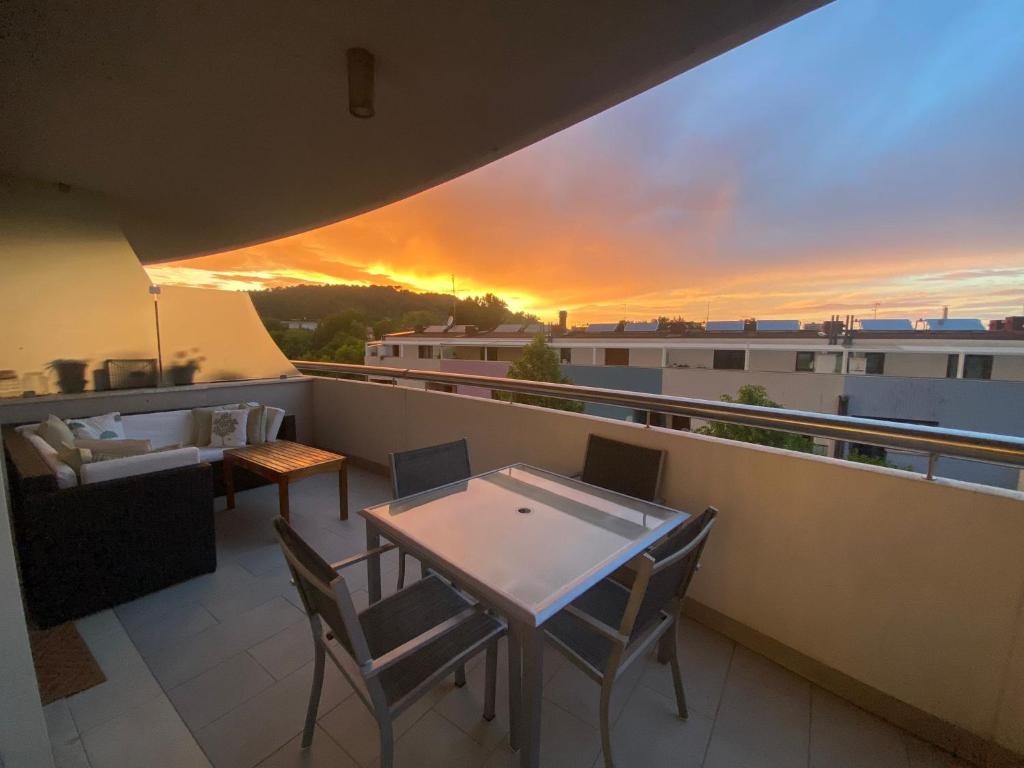 a balcony with a table and chairs and a sunset at Casa del Porto in Pesaro