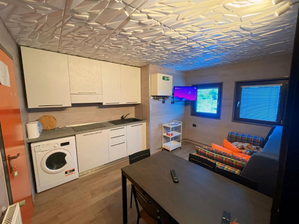 una cocina con armarios blancos y una mesa en una habitación en Biancaneve - 300 Metri dalle Piste, Free Parking e Wi-Fi en Passo del Tonale
