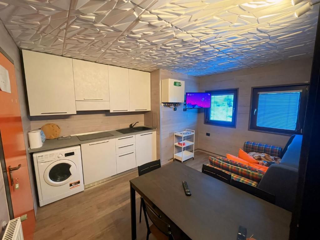 eine Küche mit weißen Schränken und einem Tisch im Zimmer in der Unterkunft Biancaneve - 300 Metri dalle Piste, Free Parking e Wi-Fi in Passo del Tonale
