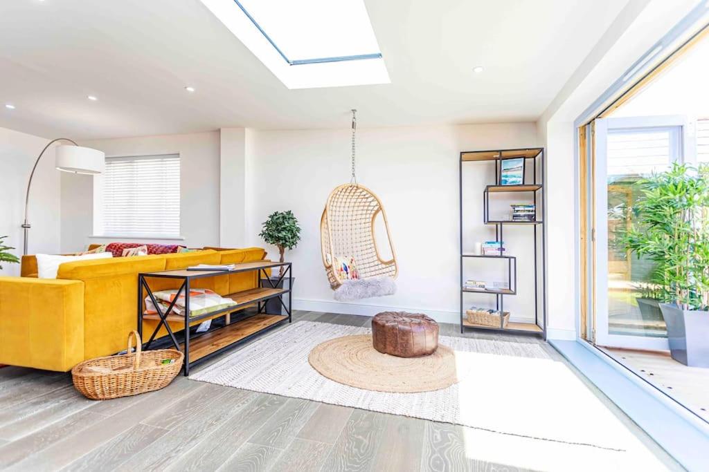 a living room with a yellow couch and a table at Luxury Ocean Playroom SEA SALT CHALET in Barton on Sea