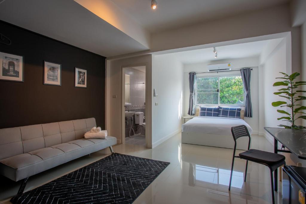 sypialnia z łóżkiem, kanapą i oknem w obiekcie Black Turtle w mieście Koh Lone