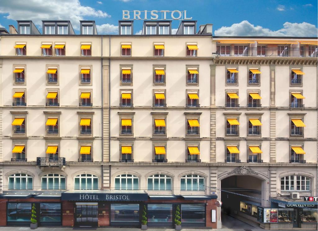 eine Fassade eines Gebäudes mit gelben Fenstern in der Unterkunft Hotel Bristol in Genf