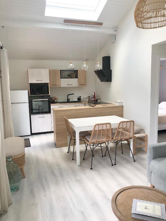 une cuisine et un salon avec une table et des chaises dans l'établissement La Palaine, maison à 150m de la mer, à La Plaine-sur-Mer