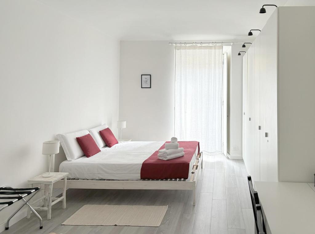 Dormitorio blanco con cama con almohadas rojas en Casa di Carlo, con Poli, metro, caffè a due passi en Turín