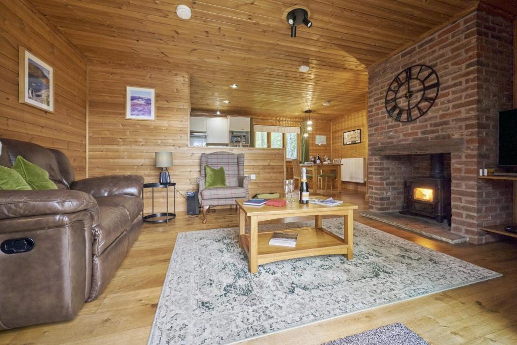 a living room with a couch and a fireplace at Gadwall Lodge with Hot-tub in Carlisle
