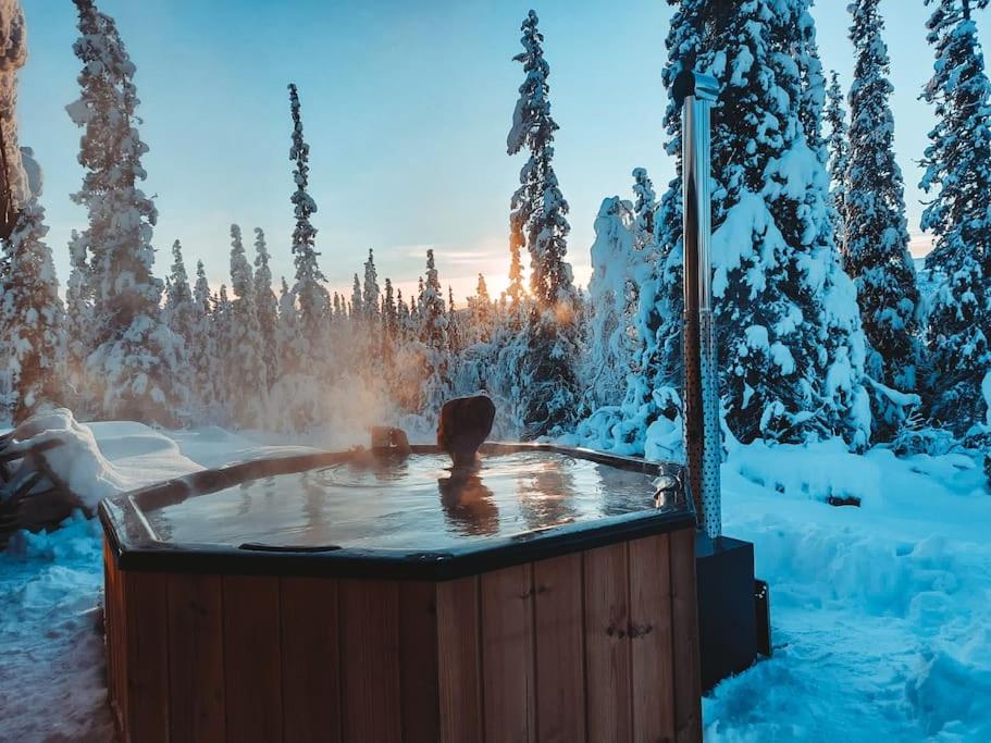 a person in a hot tub in the snow at Cozy Mountain Cottage with jacuzzi & Sauna in Beitostøl
