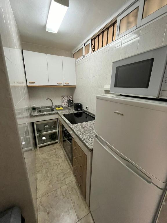 małą kuchnię z lodówką i kuchenką mikrofalową w obiekcie Apartamento Familiar w mieście Benalmádena
