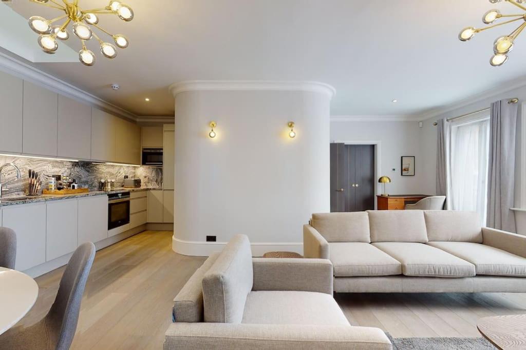 ein Wohnzimmer mit einem Sofa und einem Tisch in der Unterkunft Amazing Newly Refurbished Mews House in W1 in London