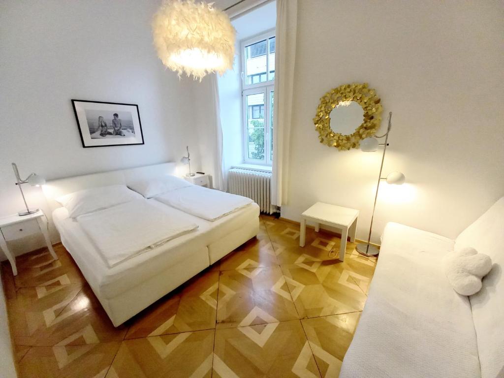 a bedroom with a white bed and a mirror at WOLKE, Apartment oder Doppelzimmer, Zentrum, am Fluss, Parkplatz in Bad Ischl