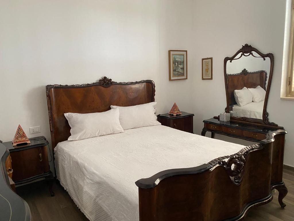 - une chambre avec un grand lit et un miroir dans l'établissement Villino Oleandro, à Santa Maria Del Focallo