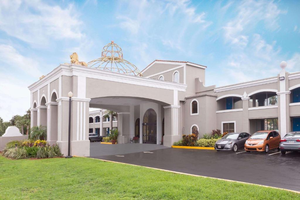 a large white building with cars parked in a parking lot at Howard Johnson by Wyndham Orlando-International Drive in Orlando