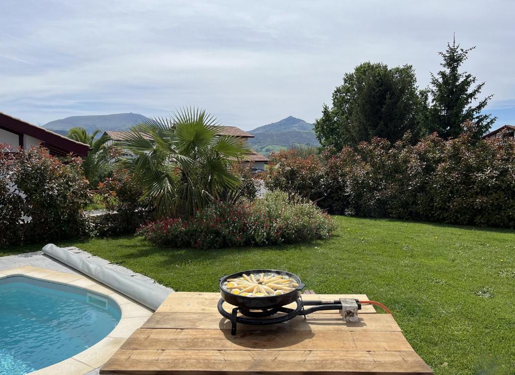 - un barbecue assis sur une table à côté d'une piscine dans l'établissement Maison 