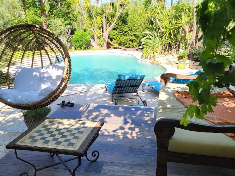 a pool with two chairs and a chess board on a patio at Villa Provence au calme avec piscine in Toulon