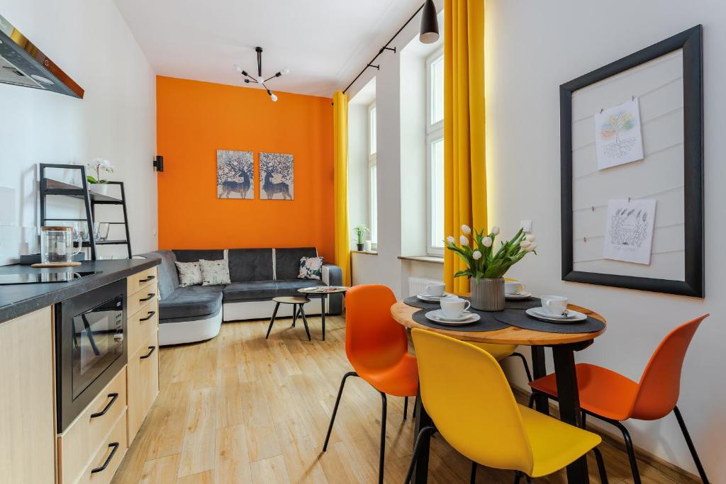 kuchnia i salon ze stołem i krzesłami w obiekcie Apartament Fair Targi Dworzec POZNAŃ Gąsiorowskich w Poznaniu