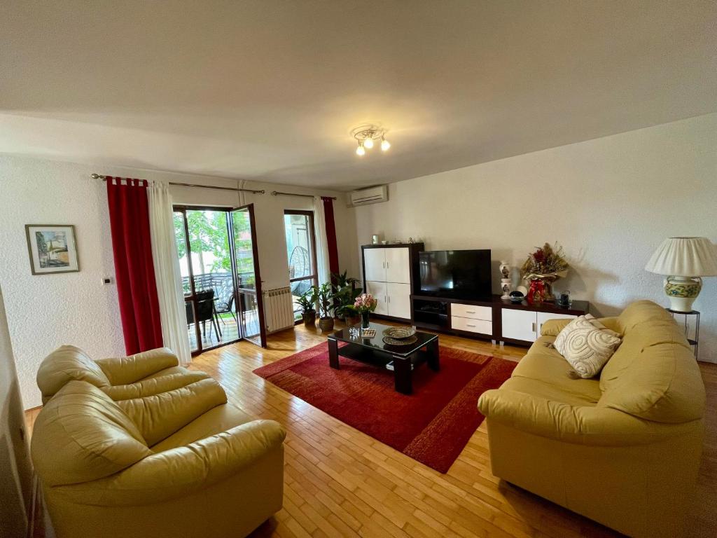een woonkamer met 2 banken en een tv bij Apartment Adri in Rovinj