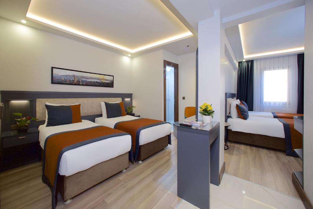 イスタンブールにあるホテル エイフェルのベッド2台とテレビが備わるホテルルームです。